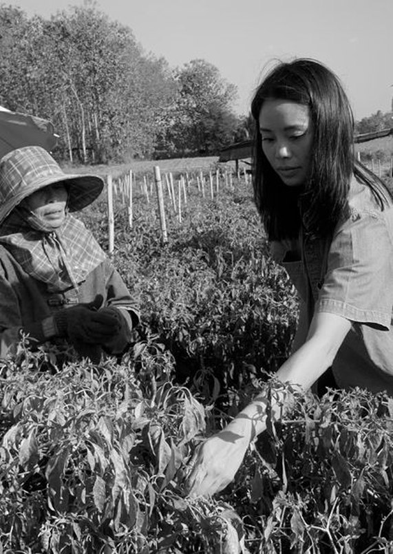 La fondatrice de Wild Rice et une productrice dans un champ de piments en Thaïlande, photo en noir et blanc